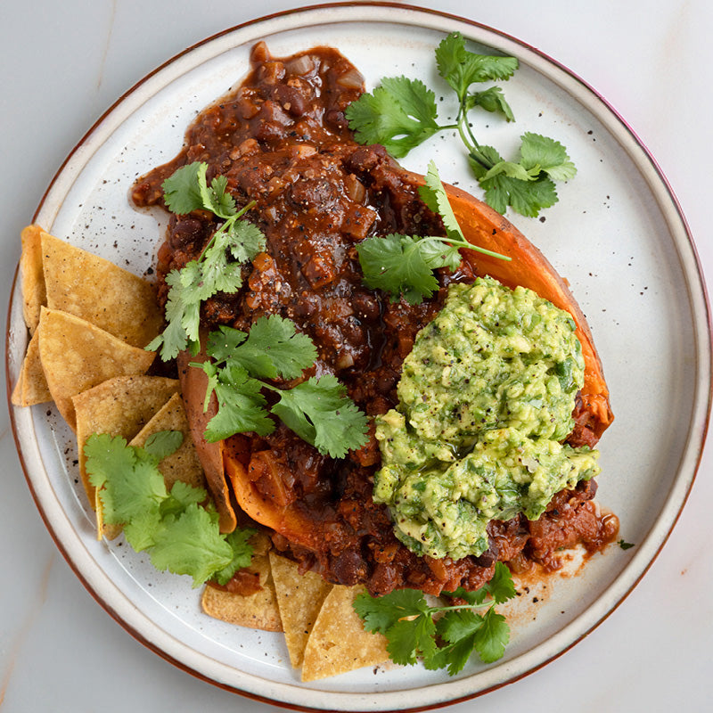 Dish photo for Superfood Black Bean Chilli Over Roasted Sweet Potato With Zingy Guacamole & Crunchy Tortilla Chips