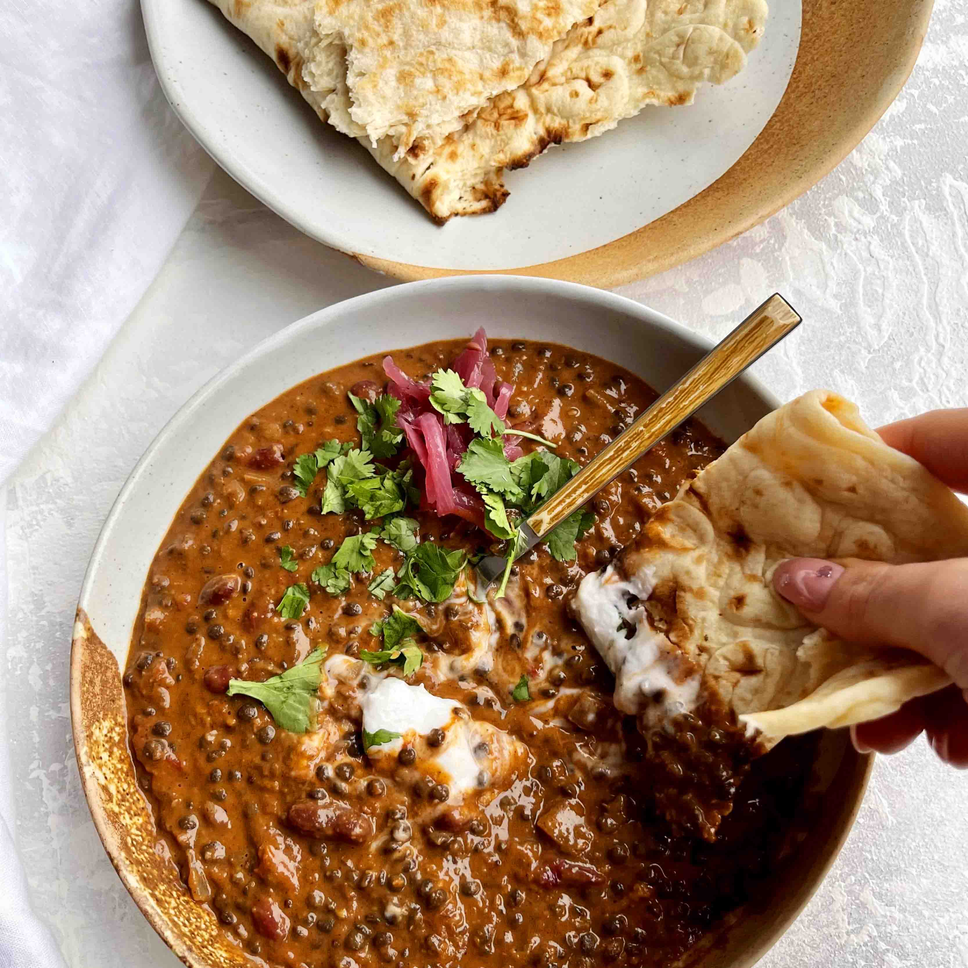 Dish photo for Rich & Luxurious Black Daal Makhani With Pickled Red Onion, Coconut Yoghurt, and Garlic & Herb Flatbread