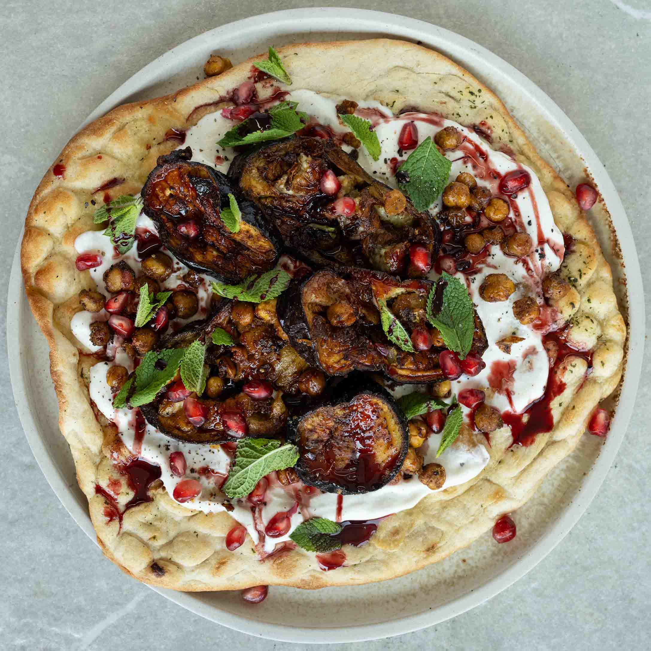 Dish photo for Middle Eastern Aubergine Flatbreads With 'Labneh', Pomegranate, Crispy Chickpeas, Garlic Tahini & Fresh Mint
