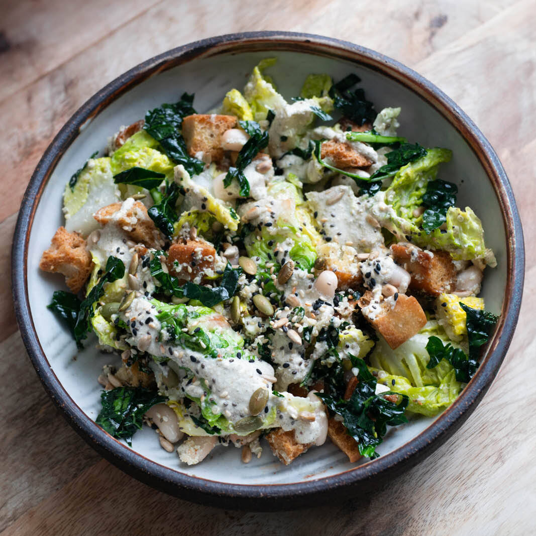 Dish photo for White Bean Kale Caesar Salad With Ciabatta Croutons, Caper Caesar Dressing & Happy Hormone Seed Sprinkle