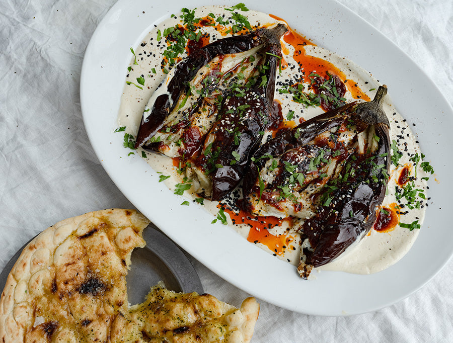 Dish photo for Smoky Whole Roasted Aubergine Over Creamy Whipped Tahini With Hot Agave Harissa, Fresh Parsley & Flatbreads