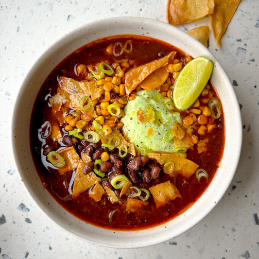 Rich & Smokey Black Bean Birria Soup With Charred Corn, Avocado Crema & Crunchy Tortilla Chips