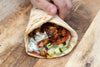 Souvlaki Style Tofu Wrap With Creamy Garlic Tzatziki, Ezme Chilli Sauce, Sumac Cabbage Onion Pickle & Fresh Salad In Soft Flatbread